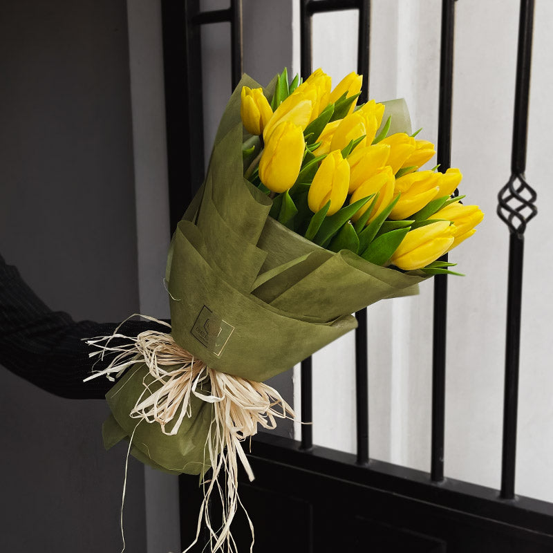 Букет от жълти лалета Емили No. 236 - Прекрасен пролетен букет от 23 жълти лалета в стилна зелена опаковка, доставка в София